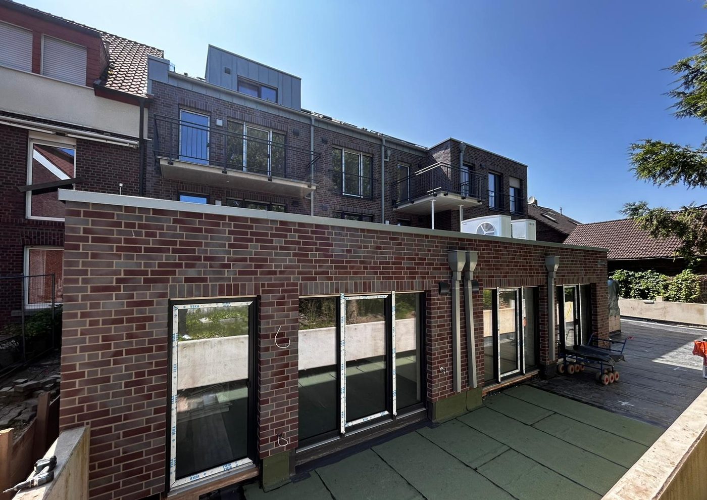 Klinkerfassade eines Staffelgeschosses mit Dachterrasse und bodentiefen Fenstern